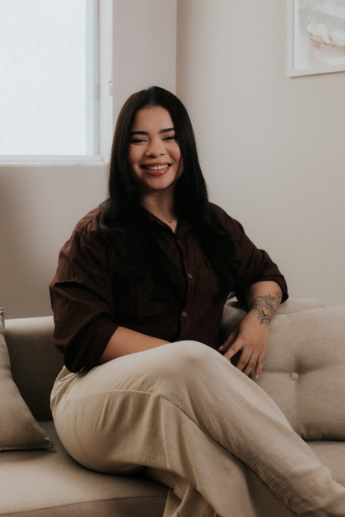 Dra. Vanessa Andrade sorrindo, sentada no consultório
